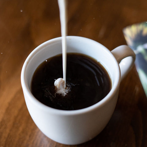 Pouring Cream in to Mug of Coffee