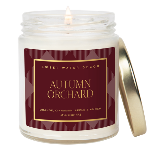 Candle in a jar with 'Autumn Orchard' label on a white background