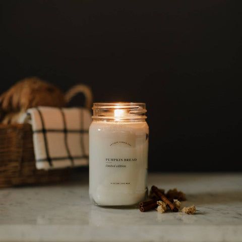 Pumpkin bread candle with cinnamon sticks on a dark background