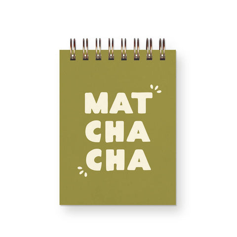 A square spiral-bound notebook with an olive green cover and the words 'MAT CHA CHA' printed in large cream letters, shown on a white background.