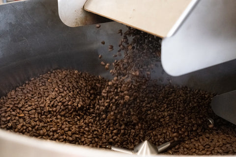 Coffee beans pouring out of a roaster
