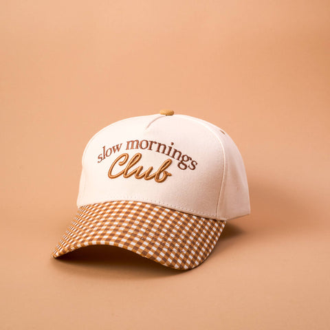 Cap with 'slow mornings Club' text on a beige background