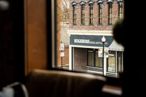 Photo of Neighbors Mercantile storefront from window inside Main Street Roasters