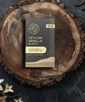 Little Prayer Tea Company Ceylon Vanilla tea package on a wooden surface with vanilla flowers and a cup of tea.