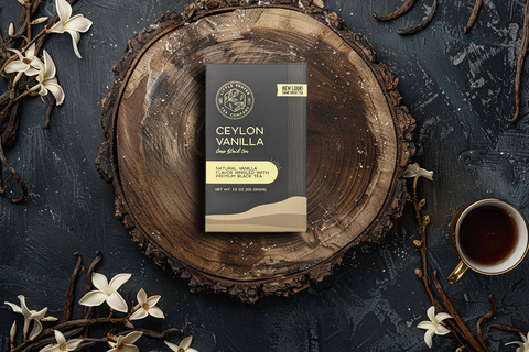 Little Prayer Tea Company Ceylon Vanilla tea package on a wooden surface with vanilla flowers and a cup of tea.