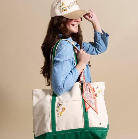 Woman wearing a cap and holding a tote bag with decorative elements on a beige background
