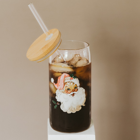 Glass of iced coffee with a Santa Claus design on a beige background
