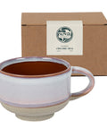 Ceramic mug with brown interior and beige exterior in front of a Nova Ceramics box.