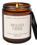 Candle in an amber jar labeled 'Mulled Cider' by Sweet Water Decor on a white background