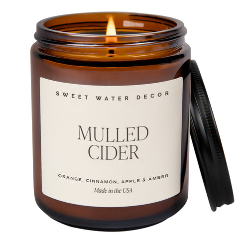 Candle in an amber jar labeled 'Mulled Cider' by Sweet Water Decor on a white background
