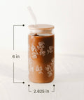 Brown tumbler with floral patterns and straw on a white background with dimensions