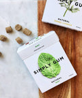 Simply Gum packaging with mint leaf design on a wooden surface