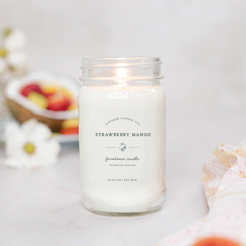 Strawberry Mango candle in a glass jar with a blurred background