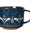 Blue ceramic mug with white floral patterns on a white background