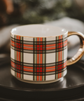 Plaid-patterned mug on a black saucer with a blurred background