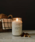Pumpkin bread candle with cinnamon sticks on a dark background