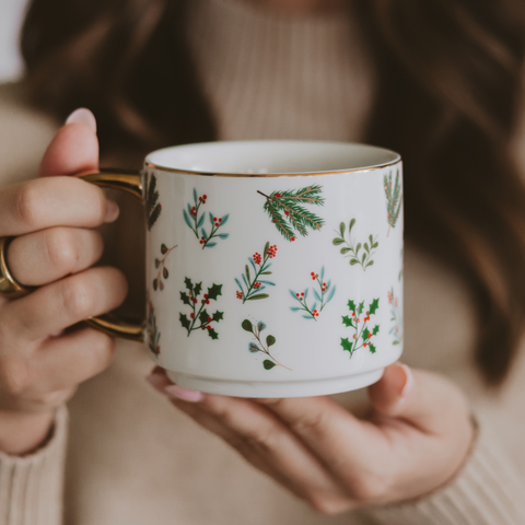 Person holding a mug with floral patterns