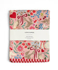 Two tea towels with a floral and bird pattern on a white background