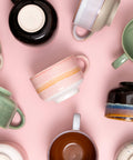 Collection of colorful mugs on a pink background