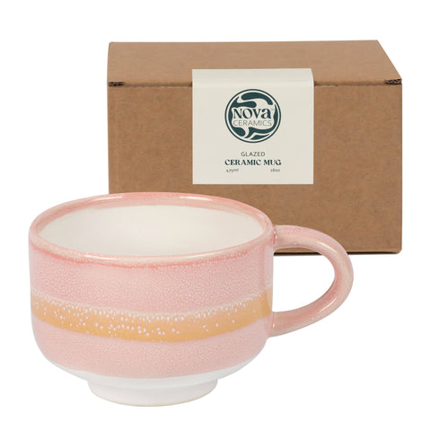 Pink ceramic mug with gold accent in front of a brown box labeled 'Nova Ceramics'.
