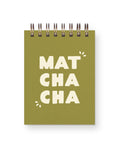 A square spiral-bound notebook with an olive green cover and the words 'MAT CHA CHA' printed in large cream letters, shown on a white background.