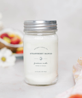 Strawberry Mango candle in a mason jar with a silver lid on a light background