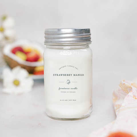 Strawberry Mango candle in a mason jar with a silver lid on a light background