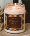 Candle with a 'Pumpkin Spice' label on a textured surface