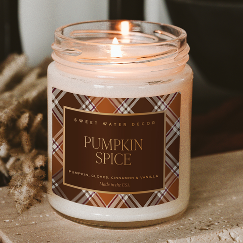 Candle with a 'Pumpkin Spice' label on a textured surface