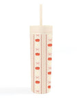 A tall, cylindrical insulated tumbler with a lid and straw, decorated with vertical stripes of orange pumpkins, bows, and zigzag lines on a cream background.