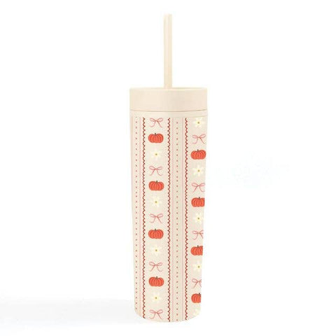 A tall, cylindrical insulated tumbler with a lid and straw, decorated with vertical stripes of orange pumpkins, bows, and zigzag lines on a cream background.