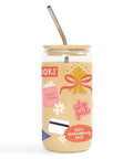 A clear glass can-shaped tumbler with a light wood lid and metal straw, decorated with colorful retro-style graphics including a yellow bow, pink text reading 'shop girl', white flowers, and a red 'HAPPY thanksgiving BACK' badge on a white background.