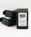 Black coffee bag labeled 'Americana Blend' with an American flag on a white background