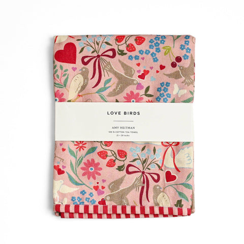 Two tea towels with a floral and bird pattern on a white background