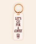 Keychain with 'Let's Go for a Coffee' text on a beige background