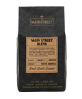 Black coffee bag with 'Main Street Roasters' branding and details about the Main Street Blend.