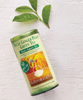 Decaf Ginger Peach Green Tea canister with green leaves on a white background