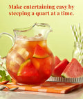 Glass pitcher of watermelon mint with watermelon slices on a polka dot napkin.