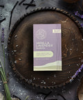 Little Prayer Tea Company Vanilla Lavender product packaging on a wooden tray with lavender and coconut elements.