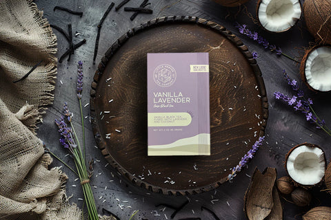 Little Prayer Tea Company Vanilla Lavender product packaging on a wooden tray with lavender and coconut elements.