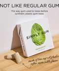 Box of Simply Gum with a mint leaf on a wooden surface
