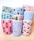 Set of colorful fabric cup sleeves with various patterns on a light background