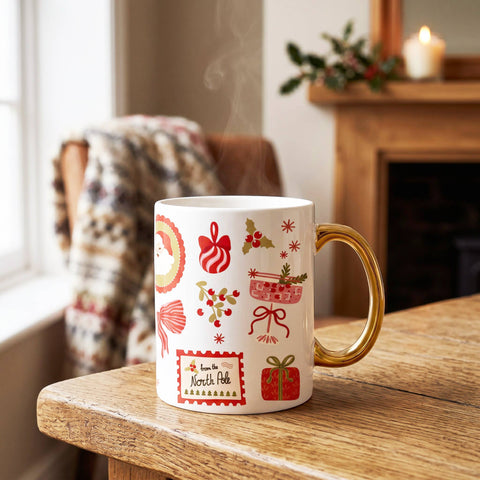 White mug with festive patterns on a wooden surface near a fireplace.