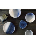 Set of ceramic bowls with blue and white gradient on a wooden surface