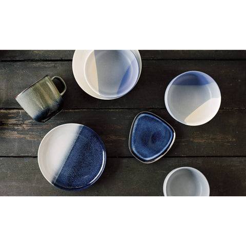 Set of ceramic bowls with blue and white gradient on a wooden surface