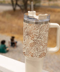 Tumbler with leaf pattern on a blurred outdoor background