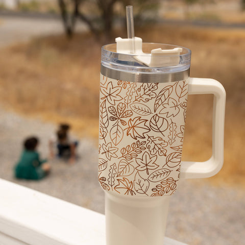 Tumbler with leaf pattern on a blurred outdoor background