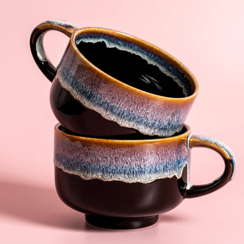 Two ceramic mugs with a gradient finish on a pink background