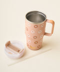 A tan insulated travel mug with a floral pattern, shown with its white lid and a clear straw on a light beige background.