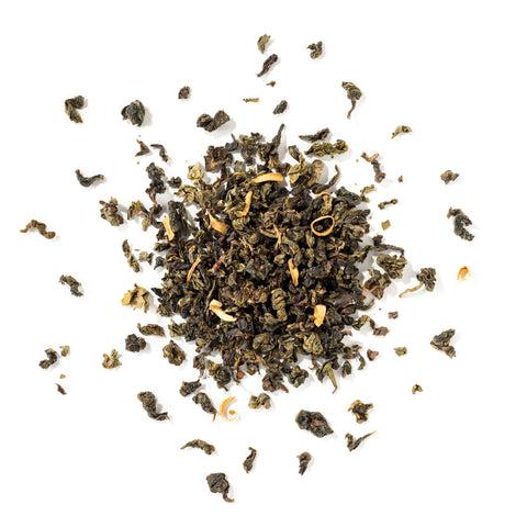 Dry green tea leaves scattered on a white background